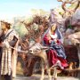 Josef geht mit dem Wanderstab voran. Er führt den Esel, der etwas widerwillig Maria mit dem Jesuskind trägt.